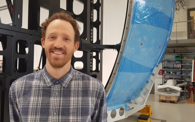 Ingenieur aus der Entwicklung Mechanik vor einer Simulatorstruktur