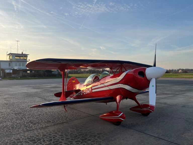 Rotes Kunstflugzeug auf dem Vorfeld in der Abenddämmerung