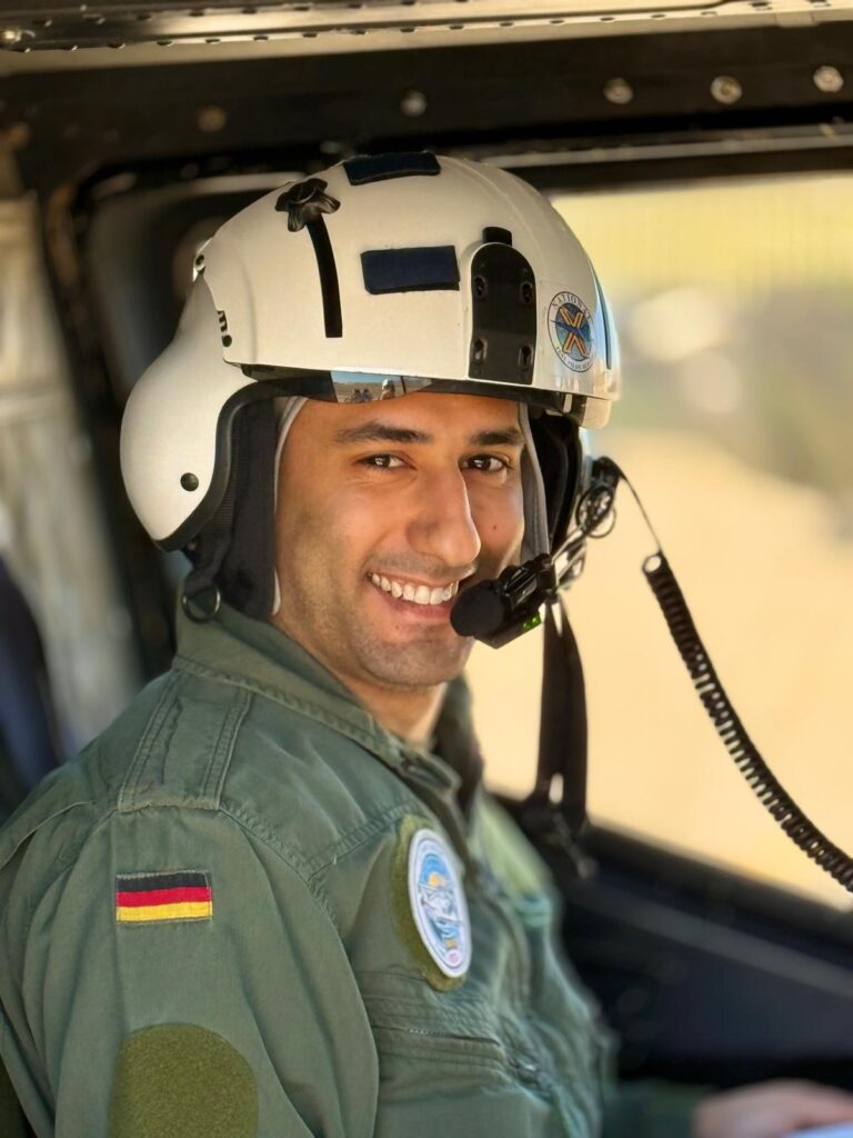 Mitarbeiter mit Flughelm im Hubschrauber