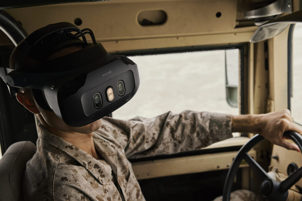 Soldier wearing a mixed reality headset at the wheel of a vehicle