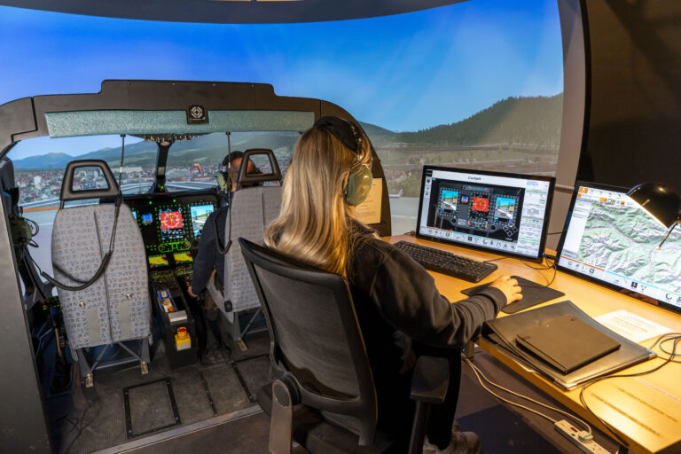 Instruktorin am Bedienplatz vor der Rundumsicht des Simulators