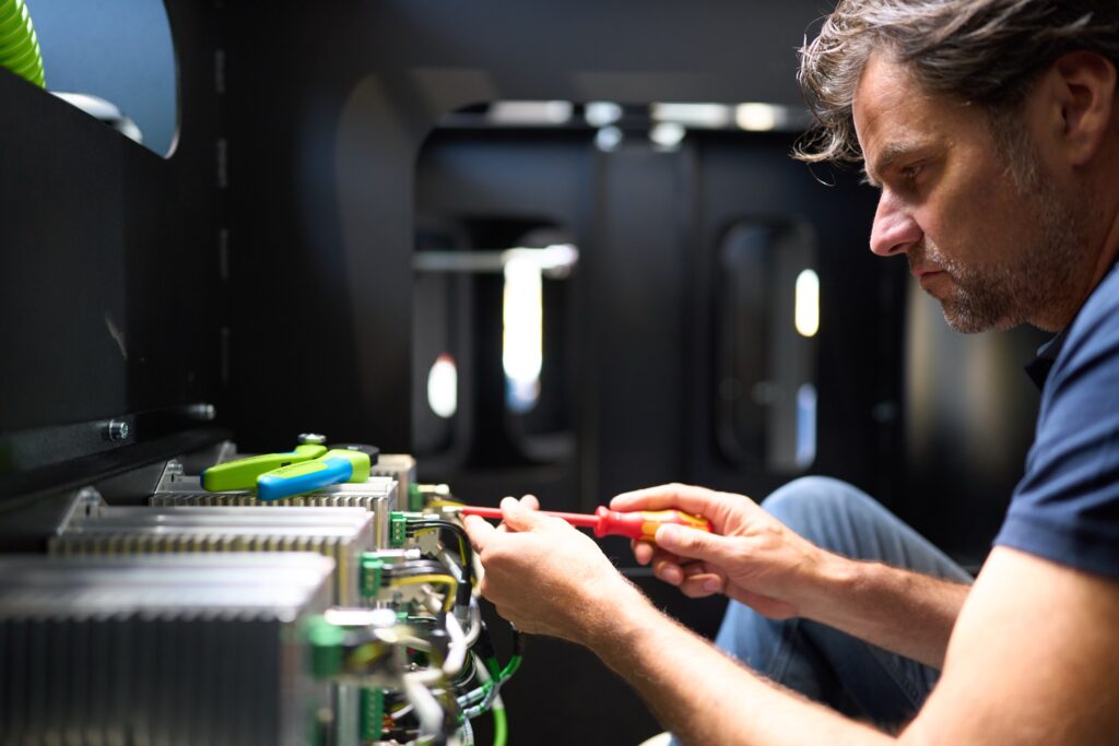 REISER Techniker verkabelt die Elektronik eines Simulators in der Produktion