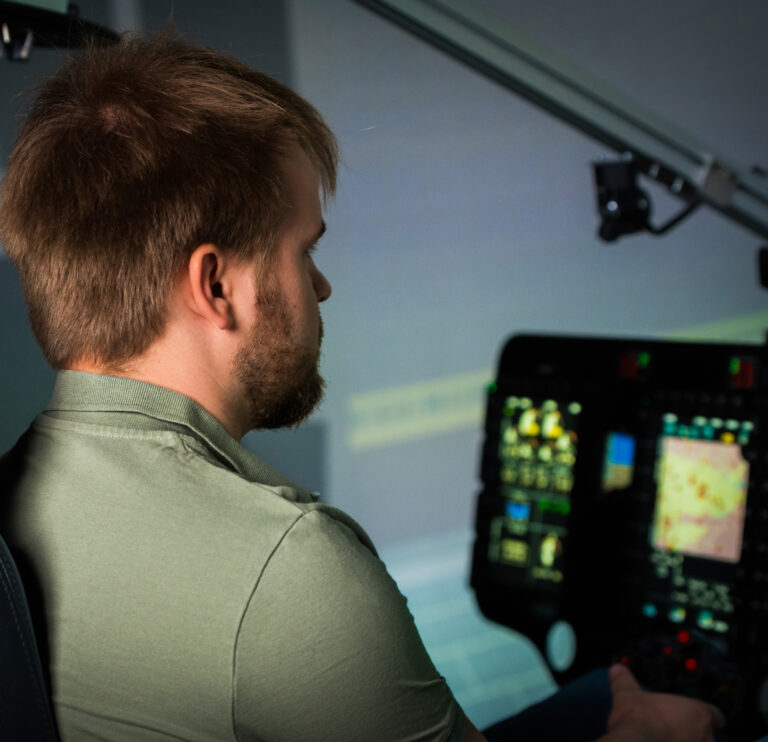Entwickler im Simulator-Cockpit vor den Displays der Bildgenerierung
