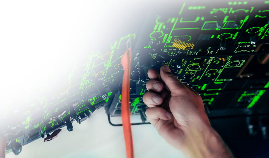 Hand an einem beleuchteten Cockpit-Panel