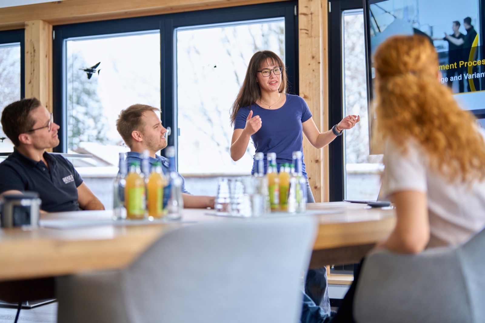 Colleague presenting to the team in a bright meeting room