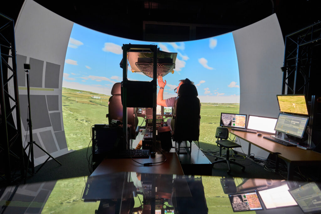 Pilot arbeitet am Overhead-Panel eines offenen Flight Training Device im Projektionsdom