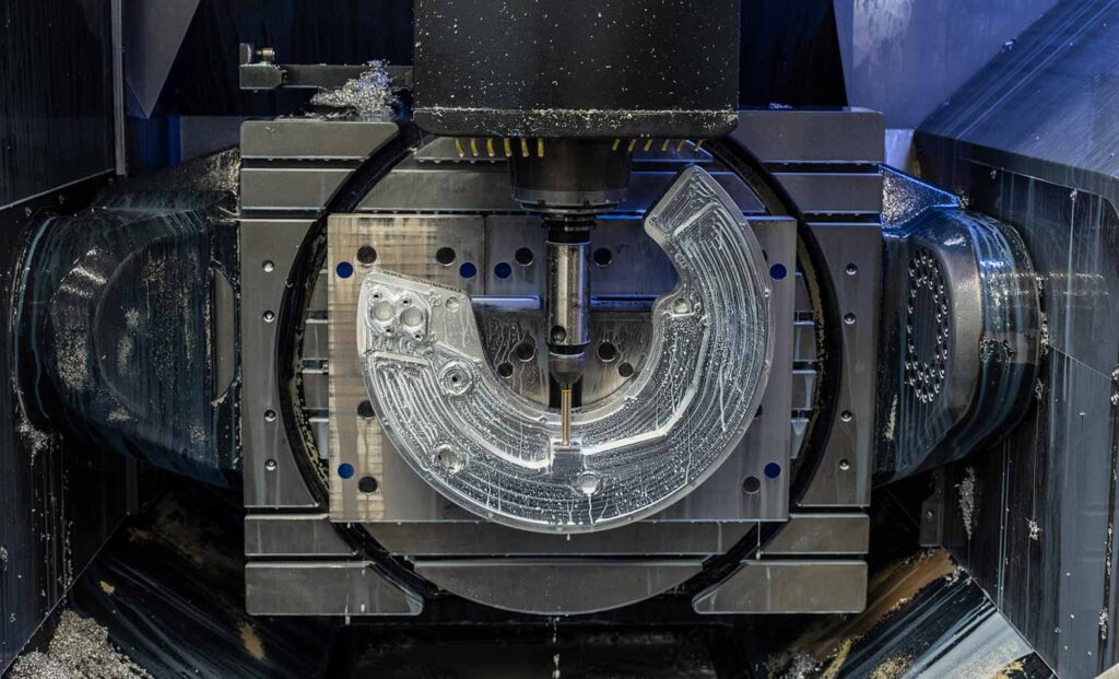 Blick in den Arbeitsraum einer CNC-Fräsmaschine mit aufgespanntem Bauteil