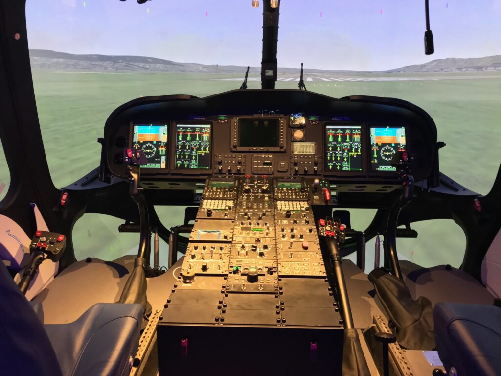 Simulator cockpit with instrument panel and visual system on final approach