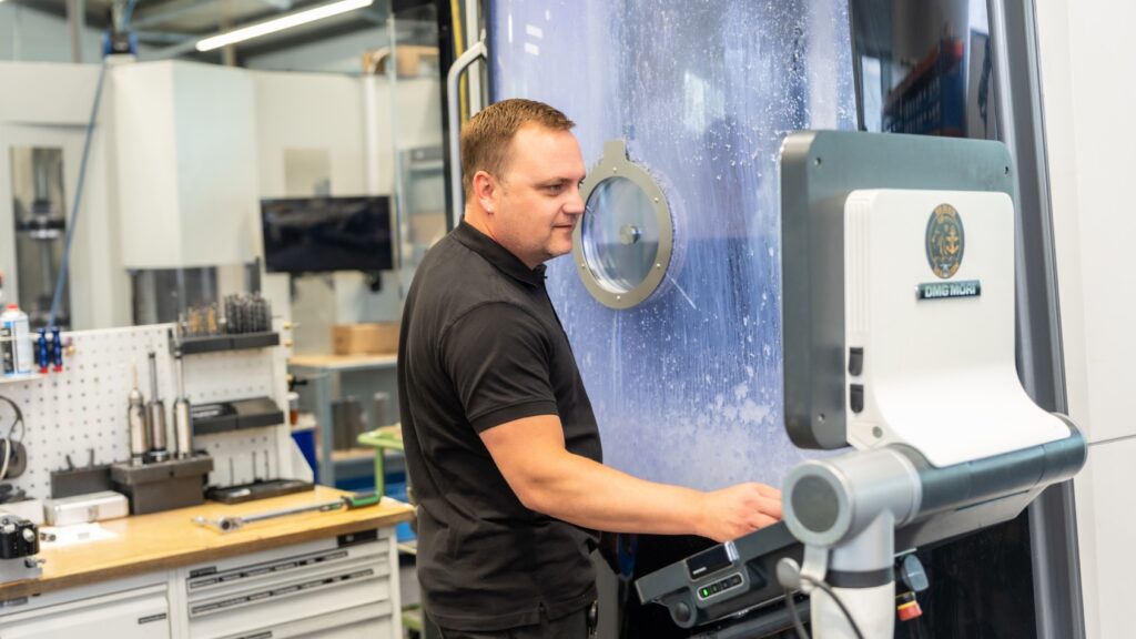 Team member clamping a workpiece in the CNC machine